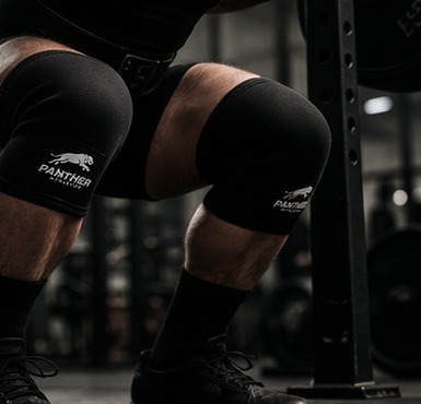 Powerlifter squatting with Panther knee sleeves