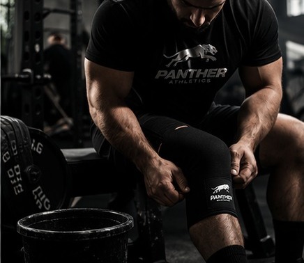 Athlete putting on knee sleeve